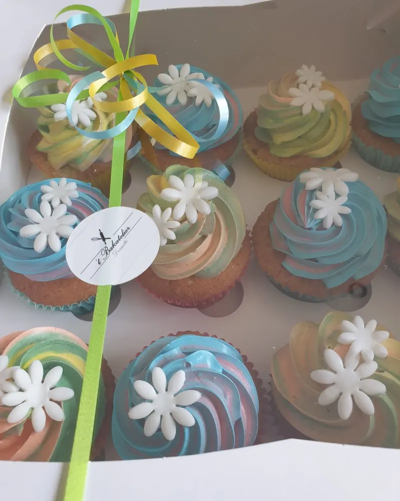 Doos pastelcupcakes met witte suikerbloemen