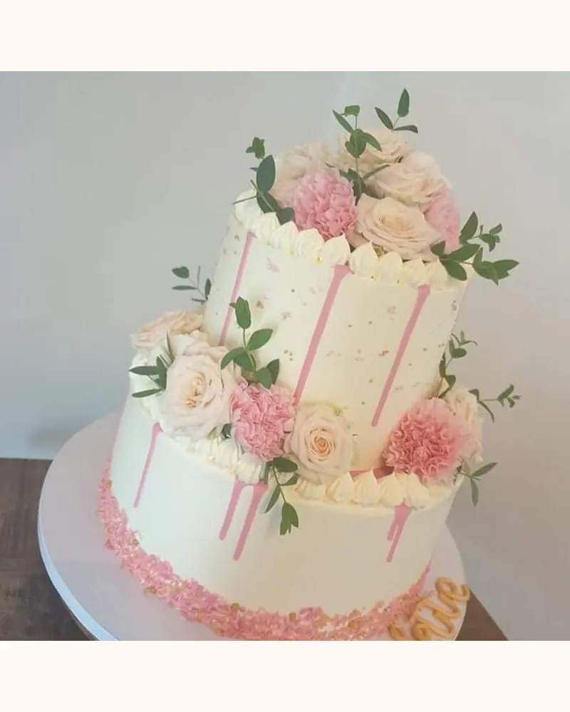 Taart met twee lagen, frambozendrip en verse bloemen
