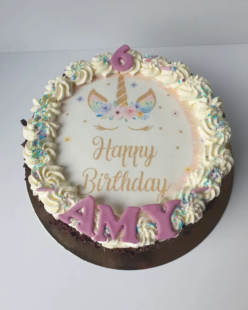 Ronde taart met eenhoornprint, "Happy Birthday" en cijfer 6