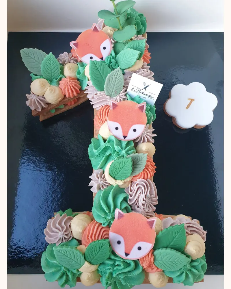 Cijfertaart in de vorm van een 1 met vosjes, groene blaadjes en rozetten